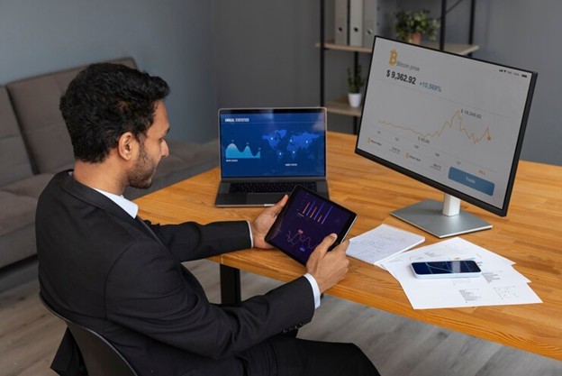 Professional monitoring financial network data on a multi-screen computer setup